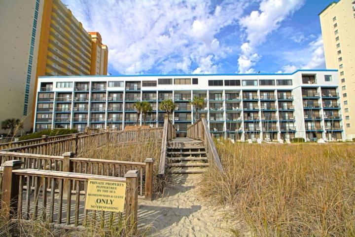 a building with a staircase in front of a building at Pepper Tree by the Sea in Myrtle Beach