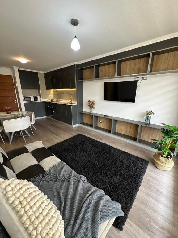 een woonkamer met een bank en een flatscreen-tv bij Maravilloso dpto 2 dormitorios in Los Ángeles