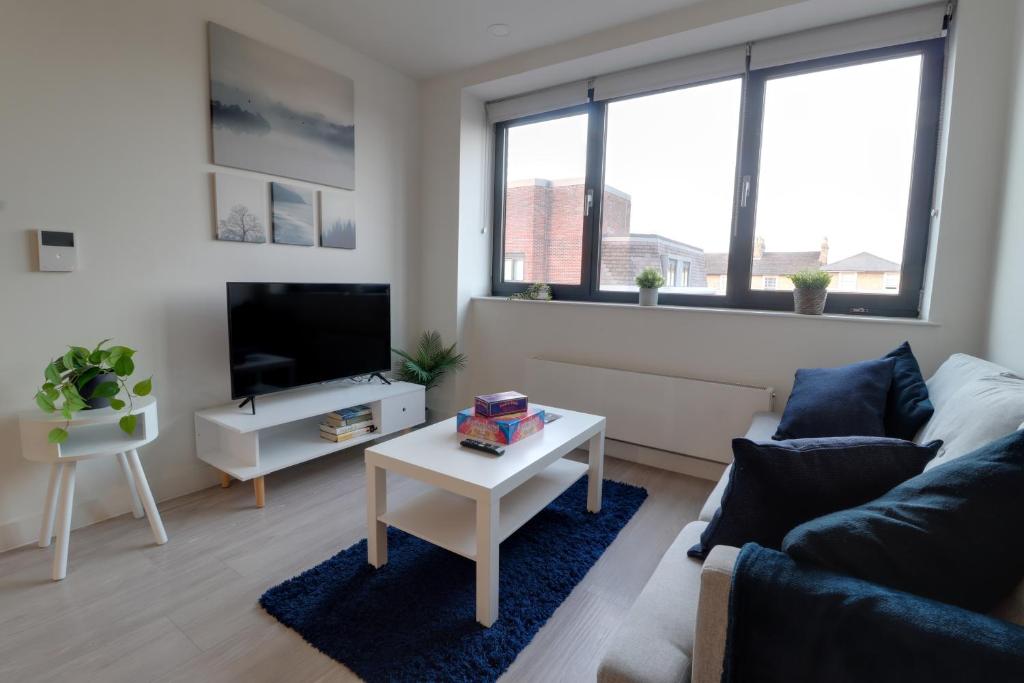 a living room with a couch and a table at Van Gogh Apartment, Bedford - Fast Wifi, Gym & FREE Parking in Bedford