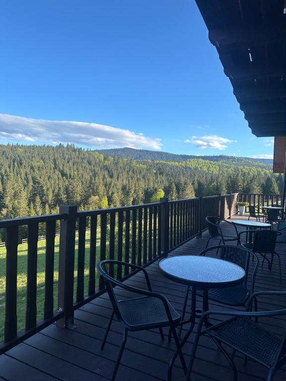 a balcony with tables and chairs and a view of the mountains at Мелодія Гір Вид на гори in Vorokhta