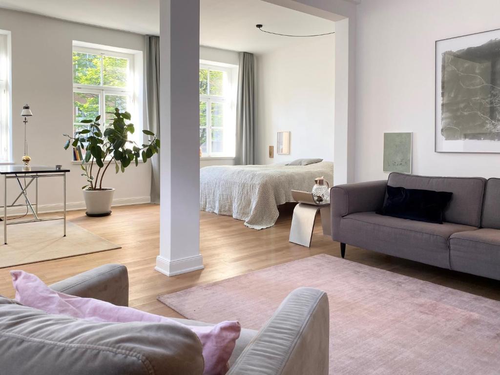 ein Wohnzimmer mit einer Couch und einem Bett in der Unterkunft Zehuus Beletage in Köln