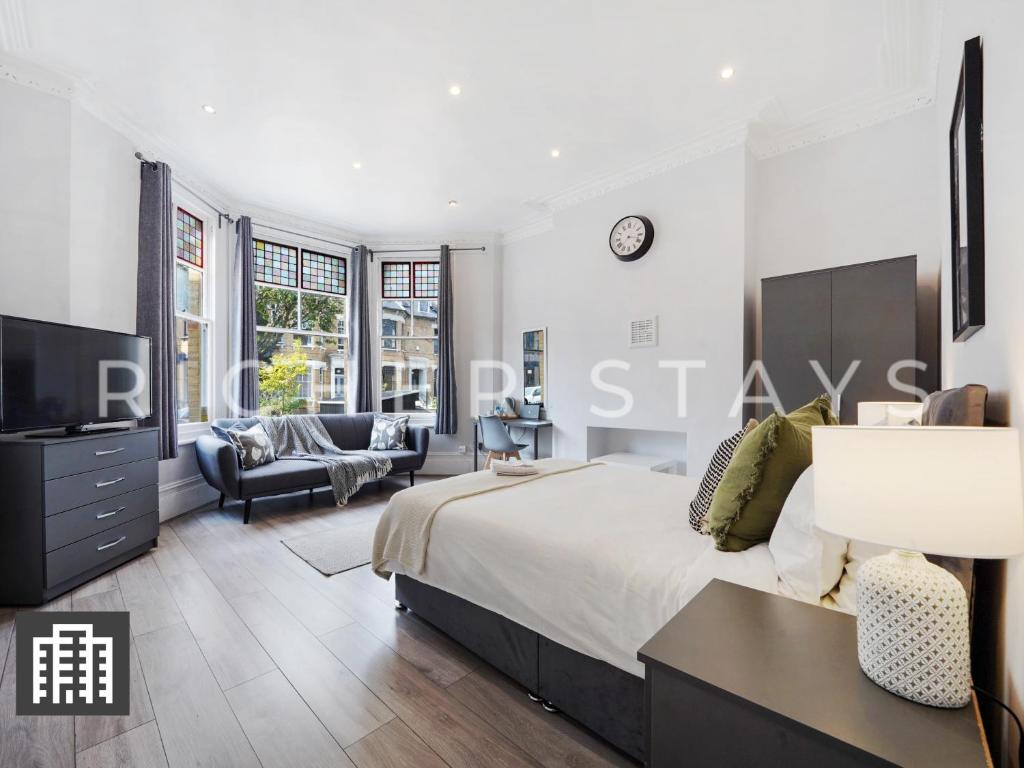 a bedroom with a large bed and a living room at Hackney Guest Rooms in London