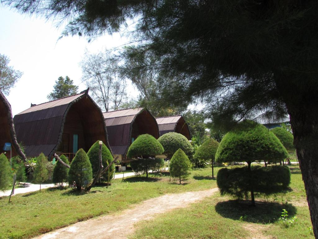 a group of trees and bushes in front of a barn at II Bungalow in Gili Meno
