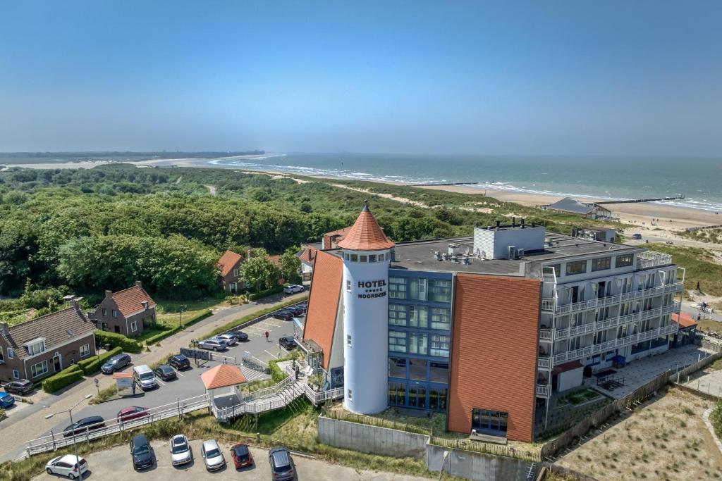 eine Luftansicht eines Gebäudes mit einem Parkplatz in der Unterkunft Noordzee, Hotel & Spa in Cadzand-Bad