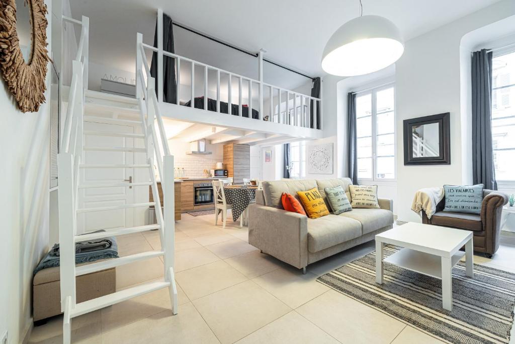 un salon avec un lit mezzanine et un canapé dans l'établissement La Petite Chaise Bleue, à Nice