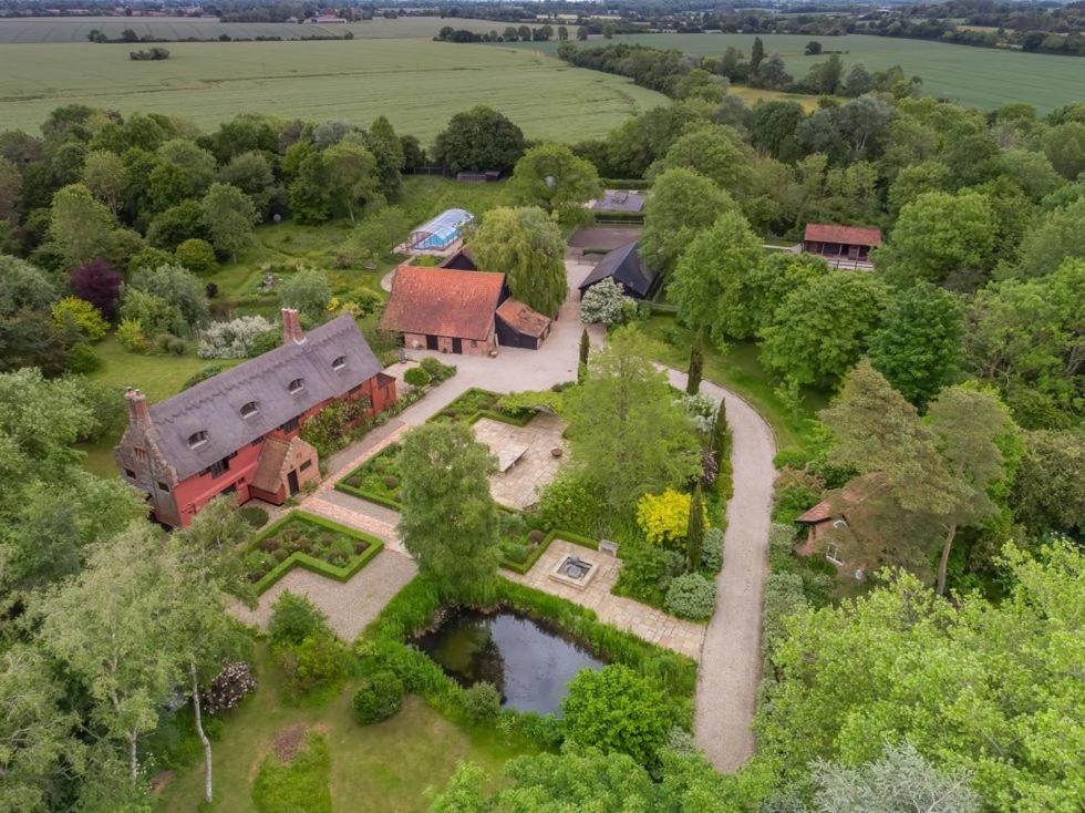 Una vista aérea de una casa con jardín y estanque. en Restaries at Paradise Farm, en Halesworth