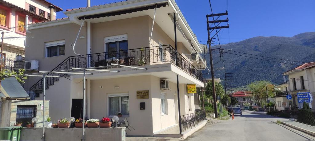 a white building with a balcony on a street at Eleni's Rooms in Ioannina