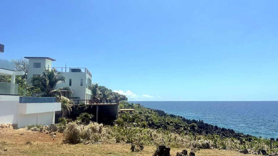 een huis op een heuvel naast de oceaan bij Casa Flomingo Roatan in West Bay