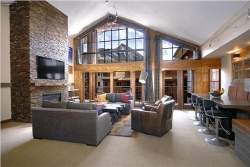 uma ampla sala de estar com sofás e um bar em The Lodge at Mountaineer Square em Mount Crested Butte