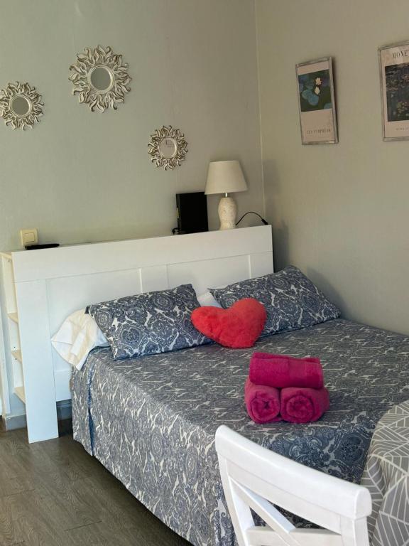 a bedroom with a bed with two red pillows at Minerva701 in Benalmádena