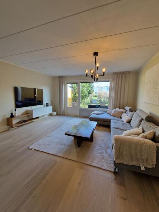 a large living room with a couch and a tv at Radhus nära sjö, Arlanda och Stockholm in Upplands-Väsby