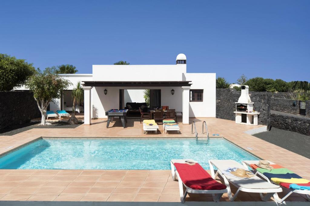 una villa con piscina y una casa en Villa Papagayo by Villa Plus, en Playa Blanca