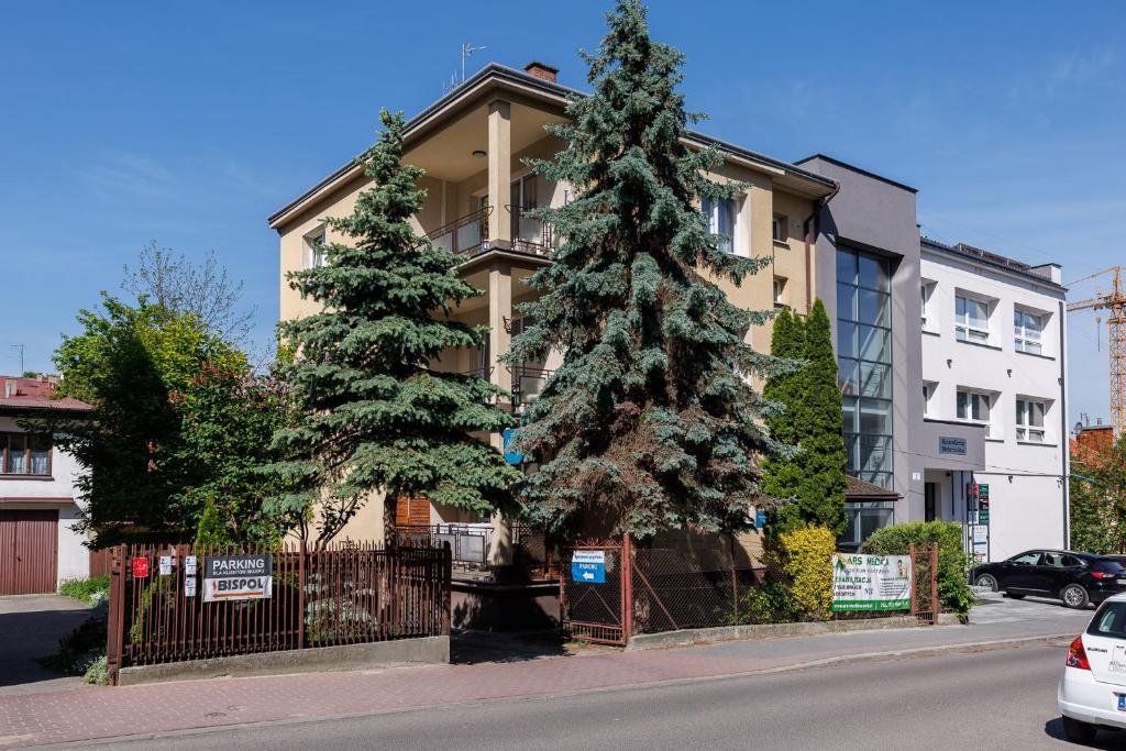 dos árboles de Navidad delante de un edificio en Apartamenty przy Parku, en Łańcut