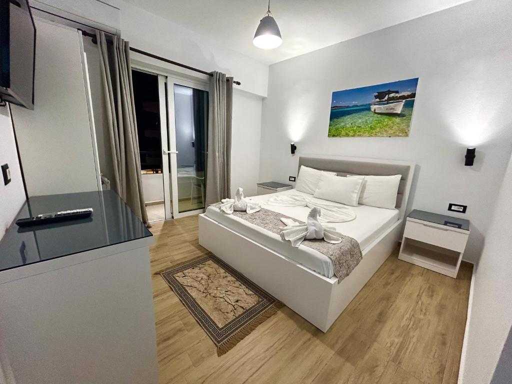 um quarto branco com uma cama e uma janela em Hotel Real em Saranda