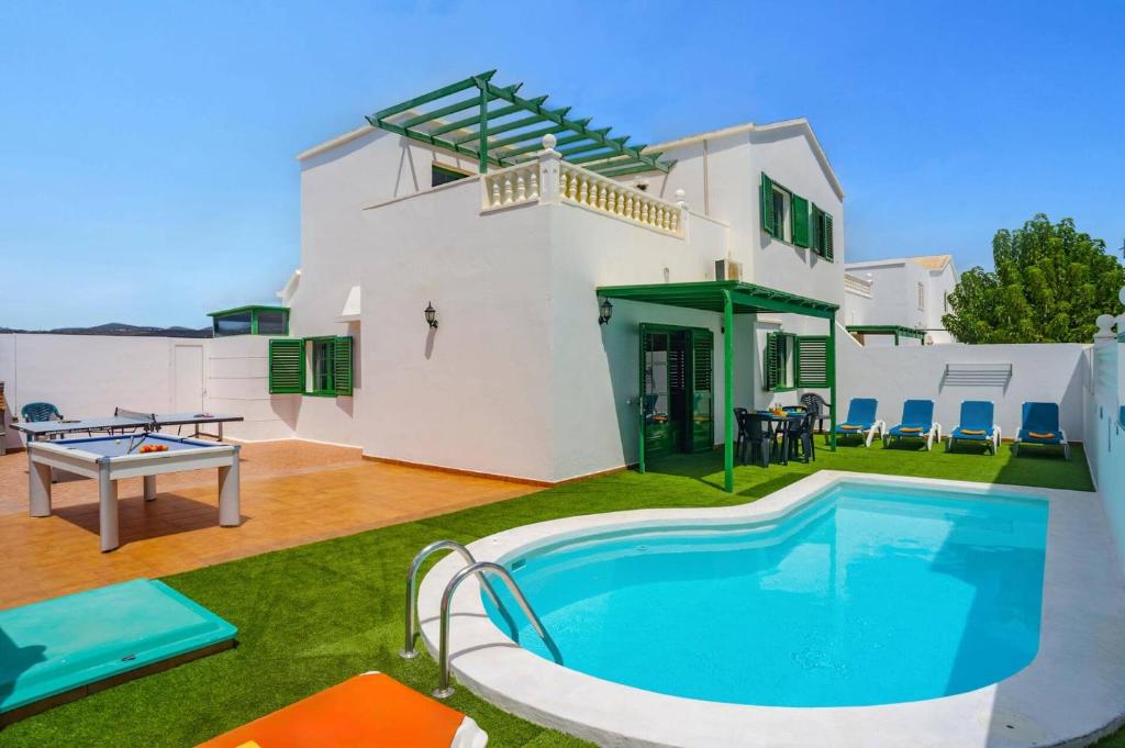 a villa with a swimming pool in front of a house at Villa Plata by Villa Plus in Puerto del Carmen