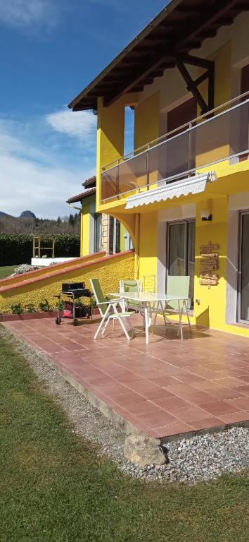 Cette maison jaune dispose d'une terrasse avec 2 chaises. dans l'établissement Gîte ensoleillé, au calme, proche Montségur, à Fougax-et-Barrineuf