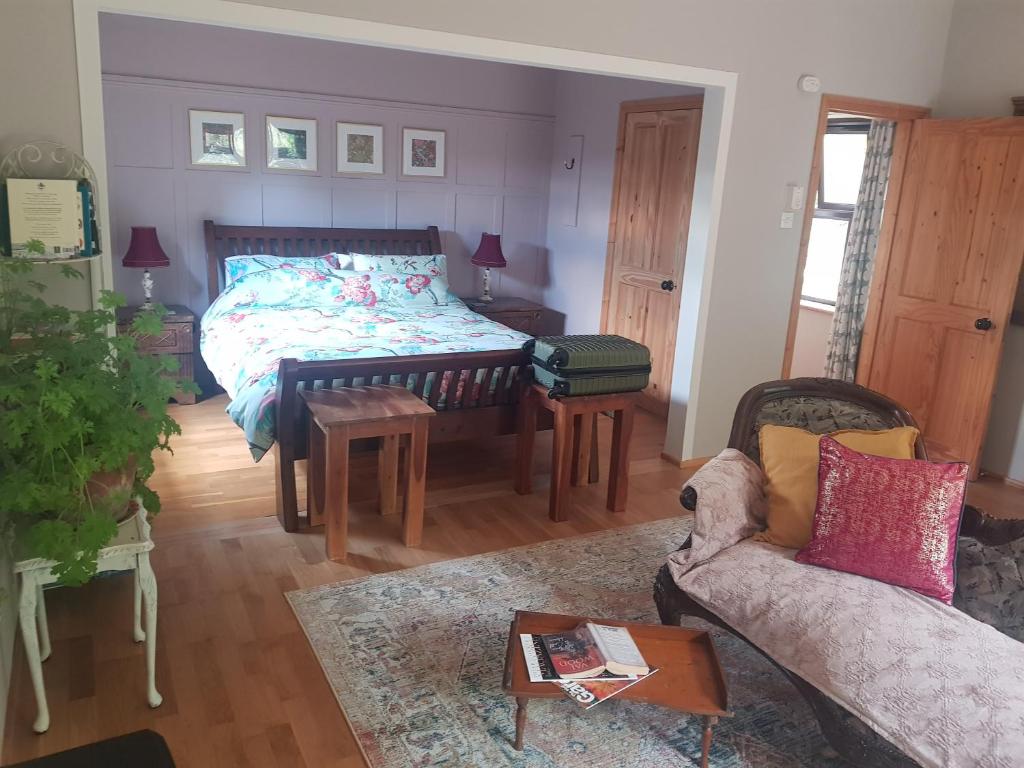 uma sala de estar com uma cama e um sofá em Pink Granite Garden of Ireland em Tinahely