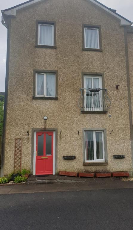 une maison en briques avec une porte rouge et des fenêtres dans l'établissement Hillside Residence, à Carrick-on-Shannon