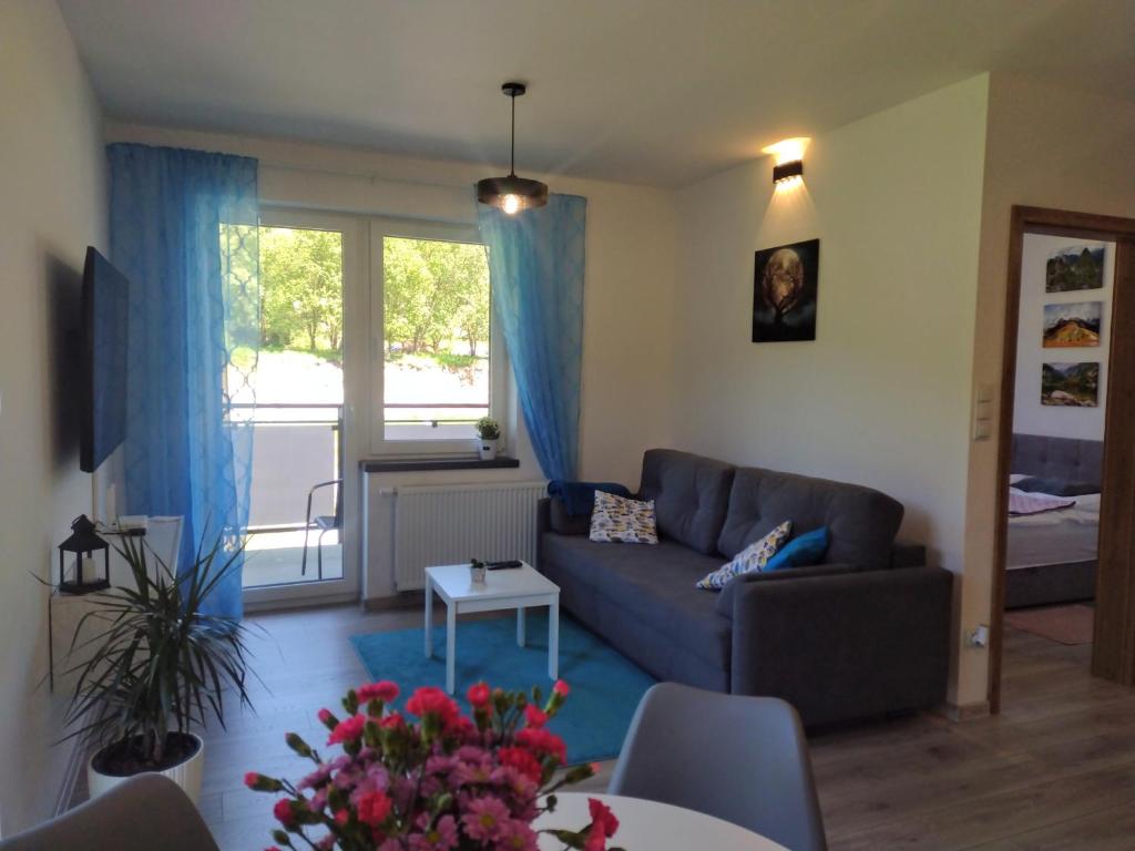 uma sala de estar com um sofá e uma mesa em Biało - niebieski em Ustrzyki Dolne
