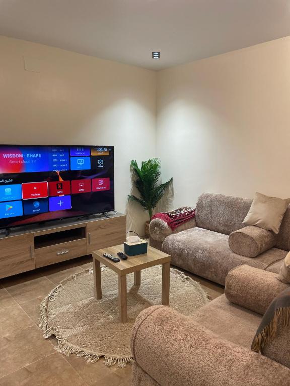 a living room with a large flat screen tv at نزل بسمة الأبداع in Abha