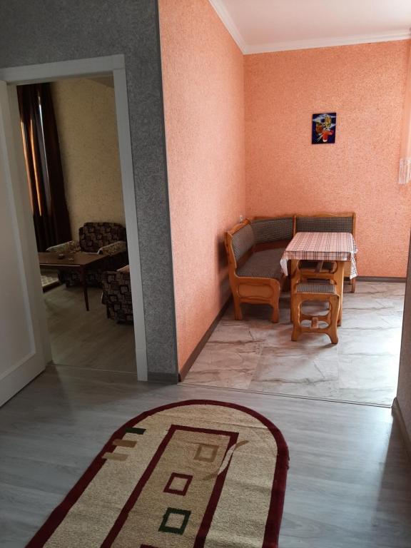 ein Wohnzimmer mit einem Tisch, Stühlen und einem Teppich in der Unterkunft Buxara apartment 