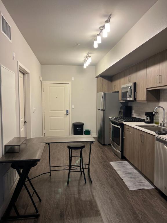a large kitchen with a table and a refrigerator at 1 Bdr Apt in Irvine - Near John Wayne in Irvine