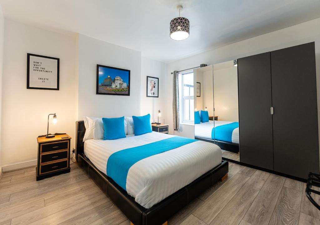 ウォルヴァーハンプトンにあるTettenhall Lodge Apartmentのベッドルーム(大型ベッド1台、鏡付)