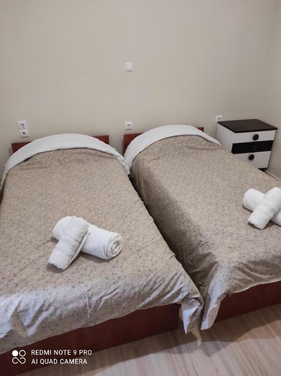 twee bedden naast elkaar met handdoeken erop bij Kalipso home in Mytilini