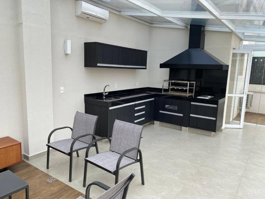 uma cozinha com 2 cadeiras, um lavatório e um fogão em 4083 - Em frente ao Hospital Albert Einstein e Estádio do Morumbi em São Paulo