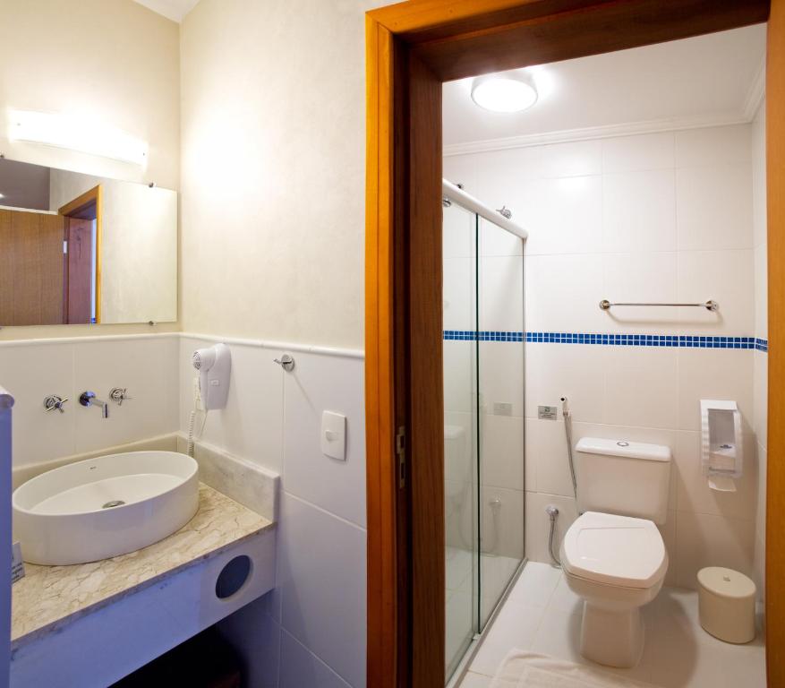 y baño con aseo, lavabo y ducha. en Hotel Fazenda Santa Monica, en Louveira