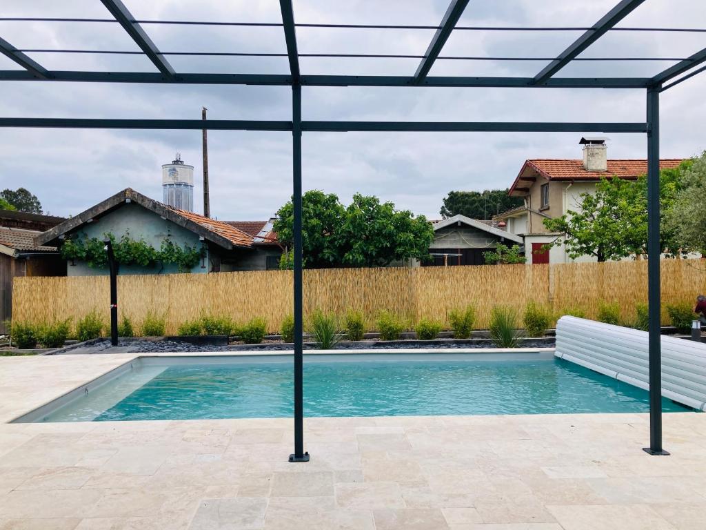 a swimming pool in a yard with a pergola at Chai Nous in Rion-des-Landes