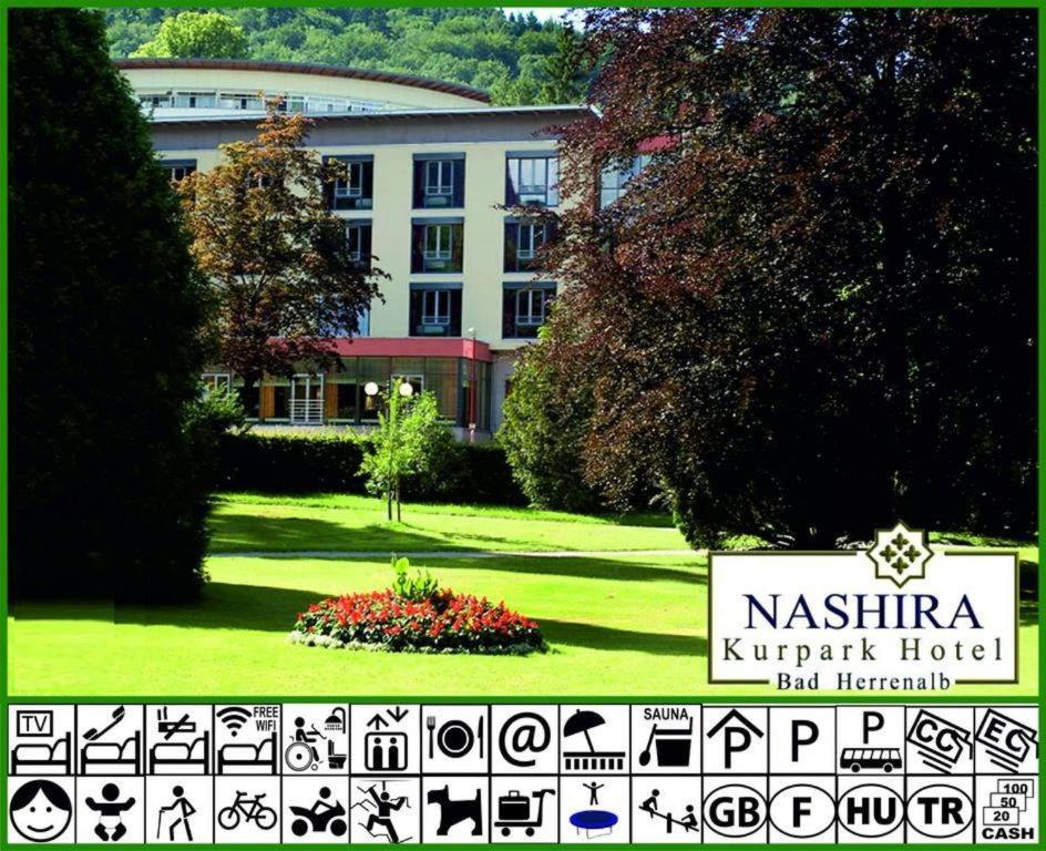 un bâtiment avec un panneau en face d'un jardin dans l'établissement Nashira Kurpark Hotel -100 prozent barrierefrei-, à Bad Herrenalb