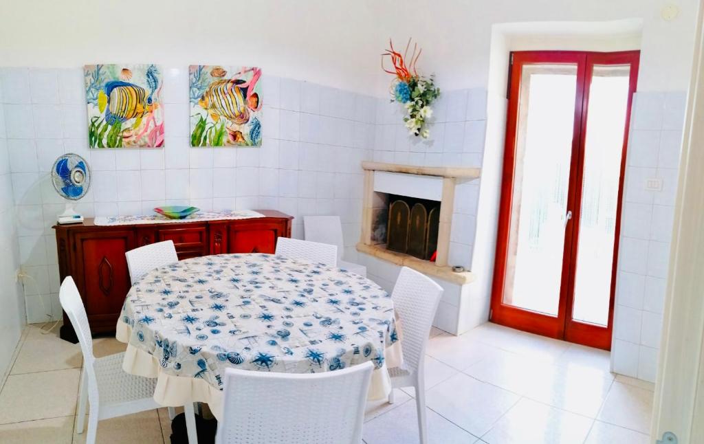 une salle à manger avec une table et des chaises blanches dans l'établissement Casa vacanze in Salento, à Racale