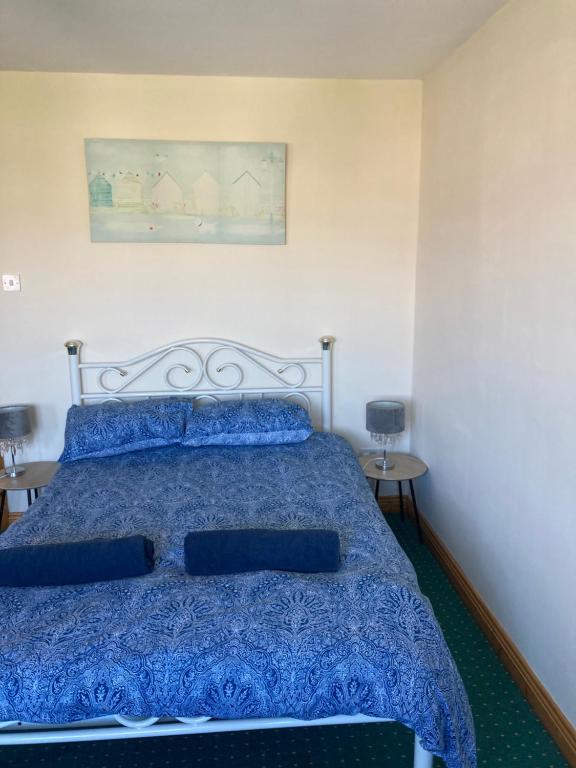 sypialnia z łóżkiem z niebieską kołdrą w obiekcie Ember w mieście Ballygerry
