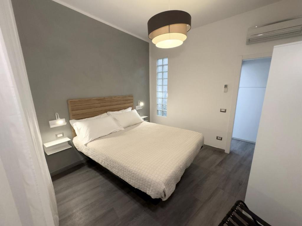 Un dormitorio con una cama blanca y una lámpara. en Berni Apartments, en Verona