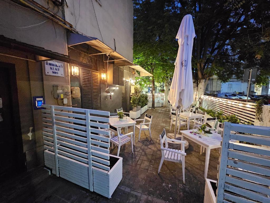 a patio with tables and a white umbrella at Private room at Ceausescu's place in Old City Unirii Square in Bucharest