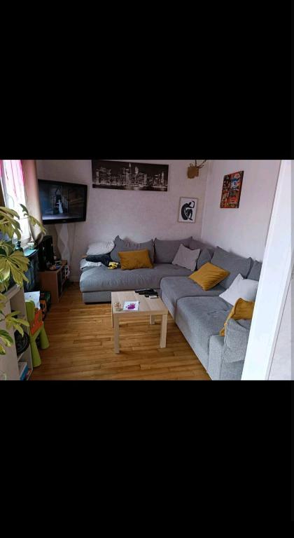 un salon avec un canapé et une table dans l'établissement Maison 2 chambres, à Saint-Léonard-de-Noblat