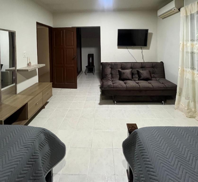 a living room with a couch and a flat screen tv at Casa bonita y cómoda in Santa Cruz de la Sierra