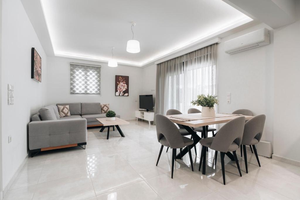 a living room with a couch and a table and chairs at Zante Melina's Apartment in Argasi