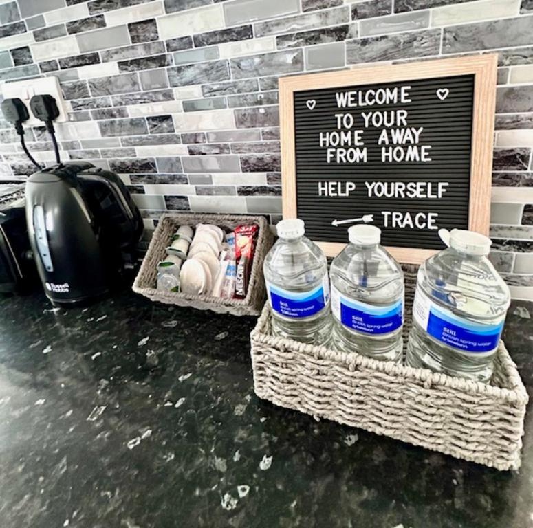 two bottles of water and a sign in a room at Gillingham 4 bed Guest House in Gillingham