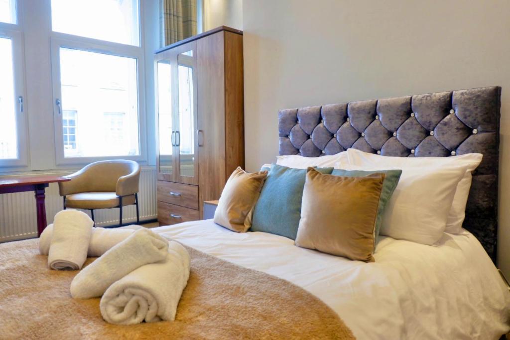 um quarto com uma grande cama branca e uma cabeceira azul em Jacobite house em Inverness