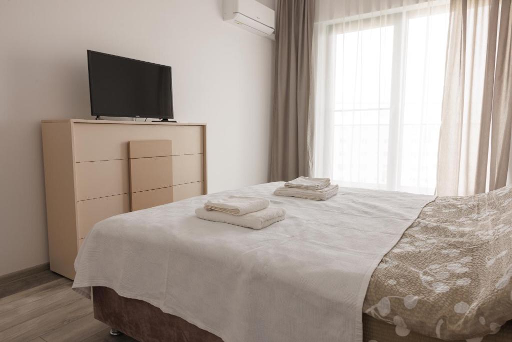 1 dormitorio con 1 cama y TV en Rescossa Apartment, en Bucarest