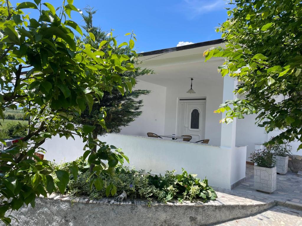 a white church with a white wall and trees at Countriside Holiday Villa 