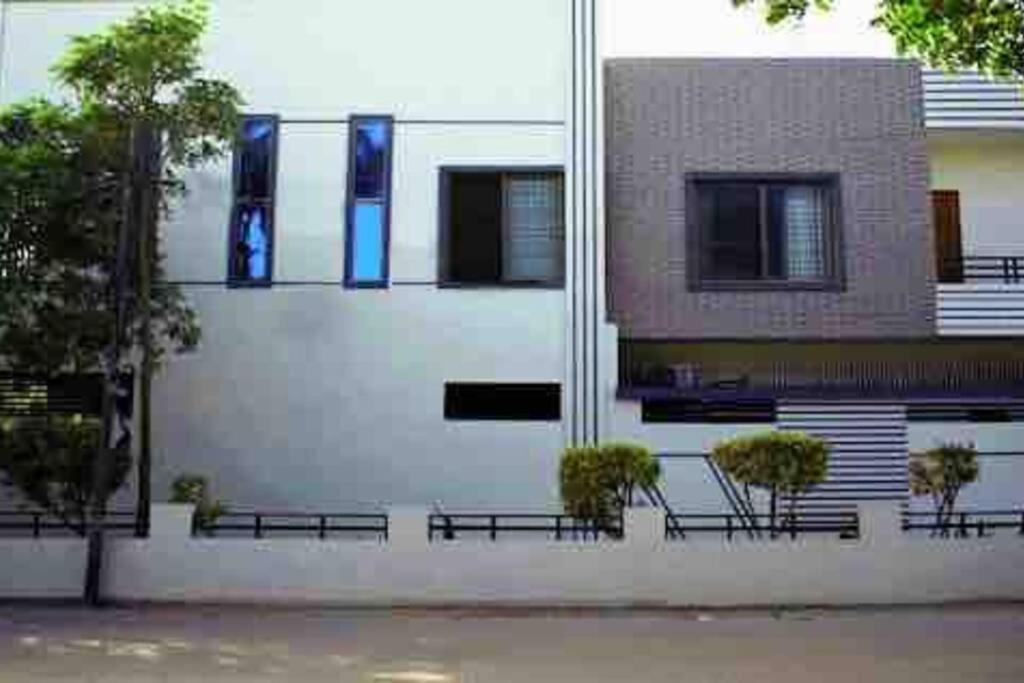 ein Gebäude mit Bänken vor einem Gebäude mit blauen Fenstern in der Unterkunft Regal Palace Gulshan Nipa in Karatschi