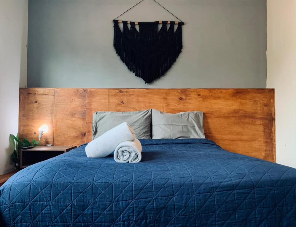 a bedroom with a blue bed with a wooden headboard at Cozy Suite In Bacab Mansion in Cancún