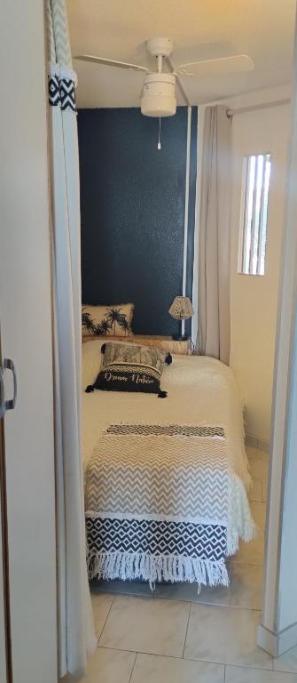 une chambre avec un lit avec un mur bleu dans l'établissement Appartement cosy sur le port, à Leucate