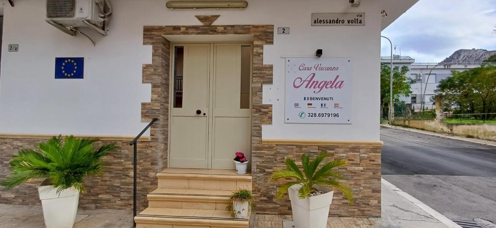 un panneau sur le côté d'un bâtiment avec des plantes dans l'établissement Casa Vacanze Angela, à Partinico