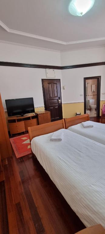 a bedroom with two beds and a flat screen tv at Villa Sv Sofija Old Town in Ohrid