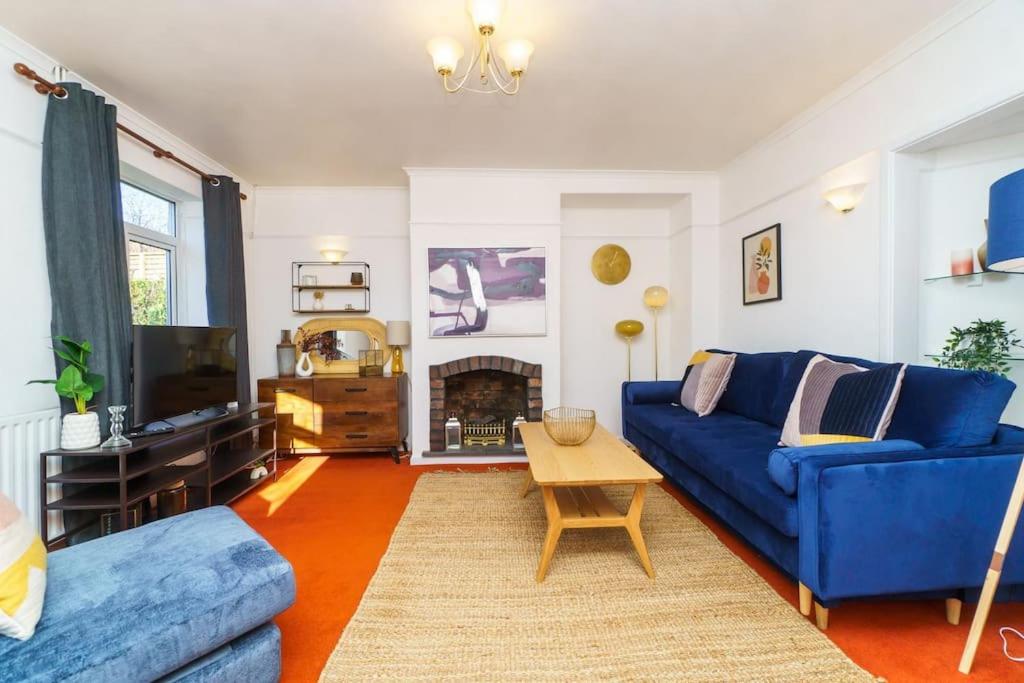 ブリストルにあるEntire 4-bed house - Bristol with Wifi, parking & dedicated workspacesのリビングルーム(青いソファ、テレビ付)