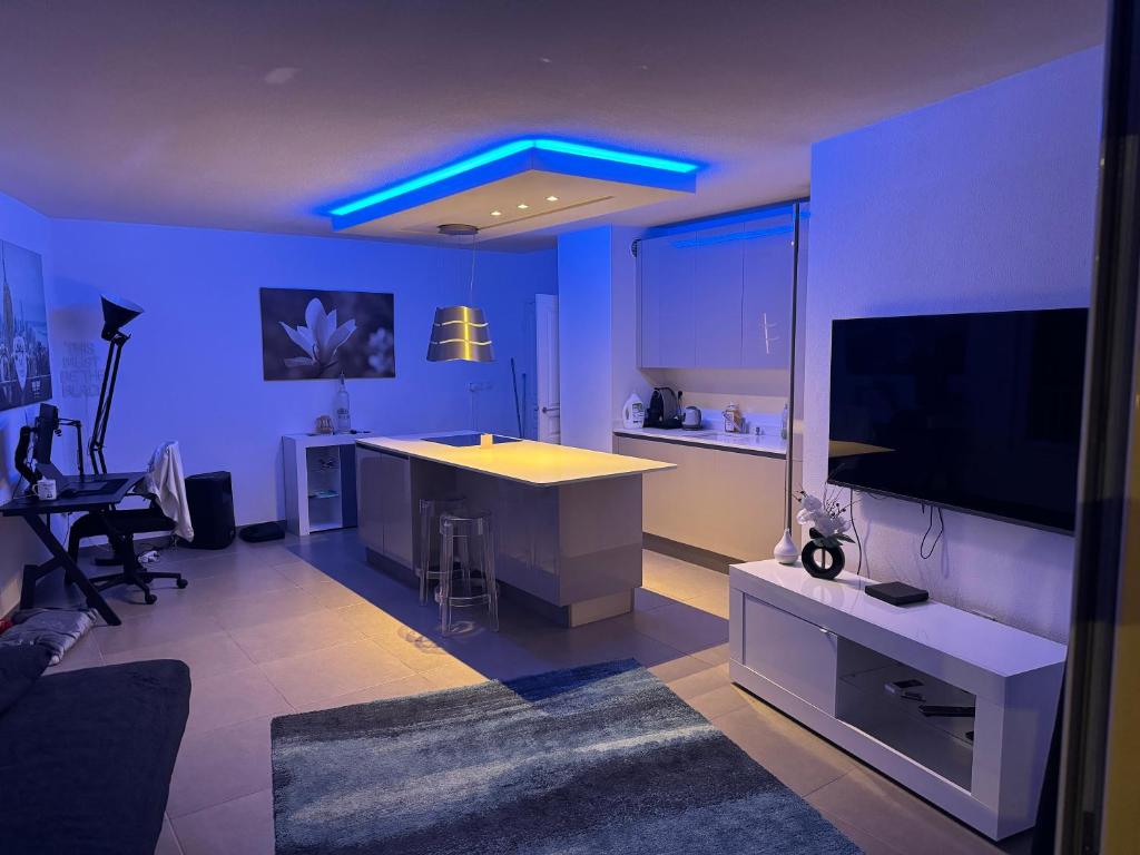 un salon avec une cuisine avec un éclairage bleu dans l'établissement Beau 2 pièces en plein centre de Cannes, à Cannes